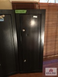 Metal gun storage cabinet with key has dent on front