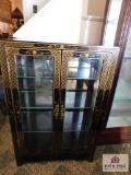 Lighted black lacquered cabinet w/ gold trim