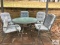 Glass top table with five chairs and cushions
