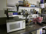 Contents of prep table: microwave, supplies, dishes, metal baskets, etc