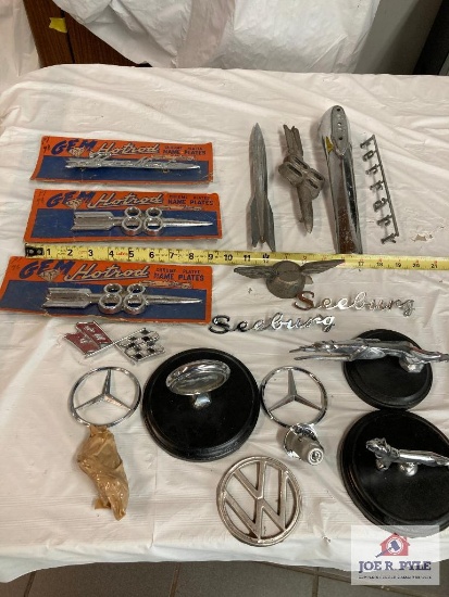 Vintage automobile items: Olds 88 emblems, Jaguar and Mercedes hood emblems, etc