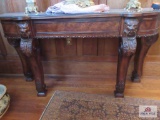 Side table with lion head adornments approx. 36 by 66 by 20 inches