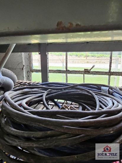 Assortment of extension cords and wire on metal shelf