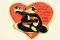 Metal heart-shaped Pepe Le Pew sign