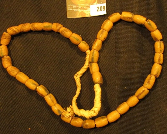 20" Strand of Old Indian Trade Beads, sand cast, strung on braided straw.