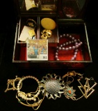 Mirrored Plastic Jewelry Box with swirled wood design containing a variety of old Costume Jewelry.