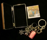 Small Silvered Jewelry Box containing a couple of rings, a Pink faceted Pendant, & a Charm Key Chain