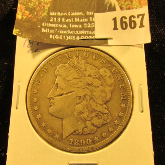 1667 . 1890 CC Morgan Silver Dollar, large scratch on face.