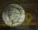1922 S U.S. Silver Peace Dollar and an old cigar box label 