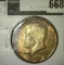 1964 Kennedy Half Dollar, BU, roll end coin, value $15