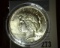 1923 P Super High Grade Silver Peace Dollar, some interesting reverse toning, encapsulated in a remo