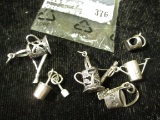 6 sterling charms, 3 watering cans, 3 sand pails and shovels, marked sterling or 925, 14.6g