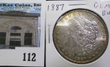 1887 P Morgan Silver Dollar, Gem BU with gold highlight toning.
