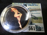 Marilyn Monroe Golden Medallion depicting Marilyn in in gold with black background on one side & nud