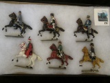 Group of 6 metal toy soldiers, all horse-mounted, in a glass front display case