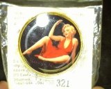 Nude Marliyn Monroe Gold-colored Medal with reverse depicting Marilyn in a flimsey red dress.