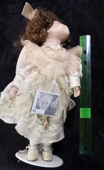 Female Doll with Brown Curly Hair on stand posing for a Kiss. Approximately 13" tall.