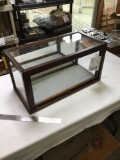 small mirrored back display case has glass sides and plastic top