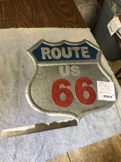 route 66 metal sign glows in headlights