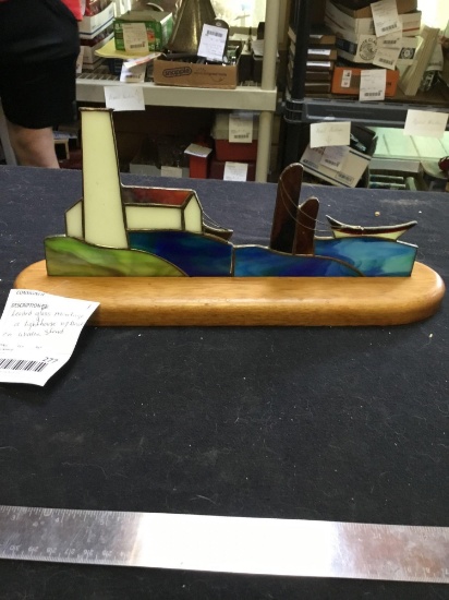 leaded glass display of a lighthouse with boat on wooden stand
