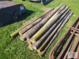 Pile of wooden fence posts, with plastic water bucket