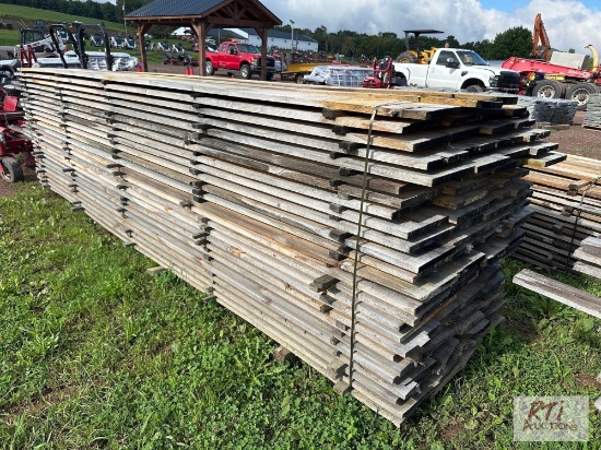 Approximately (100) pieces of 10in x 14ft rough cut lumber. Quantity and measurements are estimates.