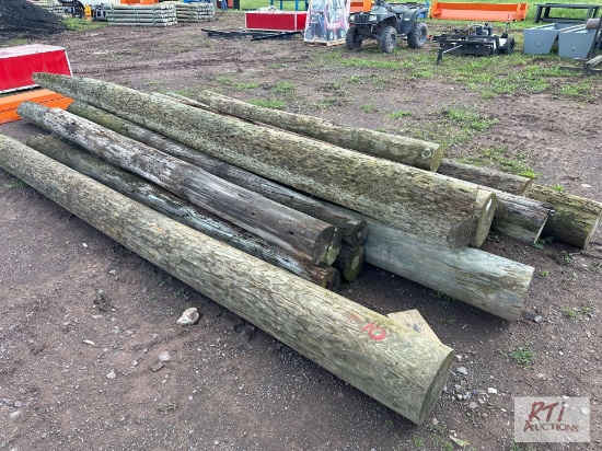 Pile of 13 mixed size telephone poles.