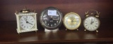 Four small alarm clocks one is Black Forest, Baby Ben, Westmoreland