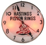 HASTINGS PISTON RINGS GLASS FACE LIGHT UP SERVICE STATION CLOCK.