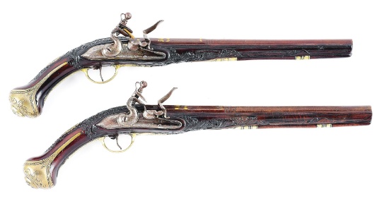 (A) LOT OF 2: A PAIR OF FLINTLOCK HOLSTER PISTOLS WITH ATTRACTIVE RELIEF CARVED STOCKS, POSSIBLY MED