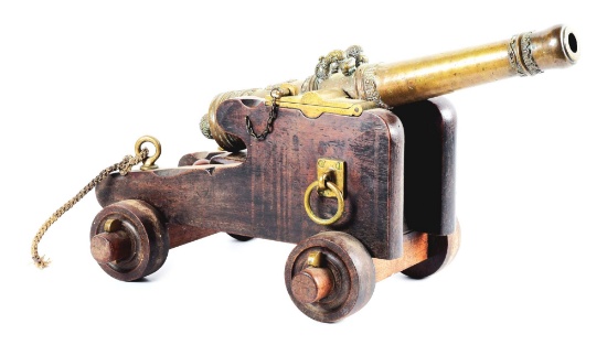 AN ATTRACTIVE, ELABORATELY CAST, BRONZE CANNON ON CARRIAGE.