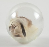 CLEAR GLASS TARGET BALL WITH FEATHERS INSIDE.