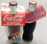Two Coca Cola Bottles With Cardboard Hang Tags