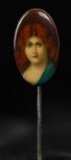 A CELLULOID STICK PIN WITH RED-HAIRED BEAUTY