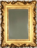 A 19TH CENTURY MIRROR WITH HEAVY ROCOCO FRAME