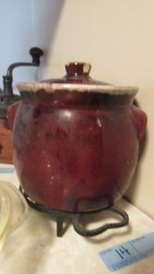 BROWN GLAZED BEAN POT ON METAL TRIVET, CHIP ON LID