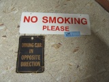 METAL NO SMOKING SIGN AND CARDBOARD DINING CAR IN OPPOSITE DIRECTION SIGN