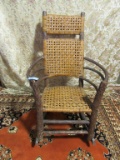 PRIMITIVE ROCKER WITH WOVEN SEAT AND BACK. ONE ARM BROKEN