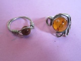 2 AMBER COLOURED STONES RINGS