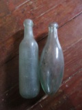 2 ROUND BOTTOM GLASS BOTTLES. ONE HAS NUMBER 12 ON THE BOTTOM