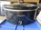black crock pot with glass lid and insert. plastic is chipped on handle.
