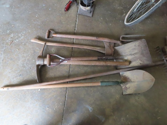 variety of yard and garden tools including axe, pitchfork, shovels, and pickaxe