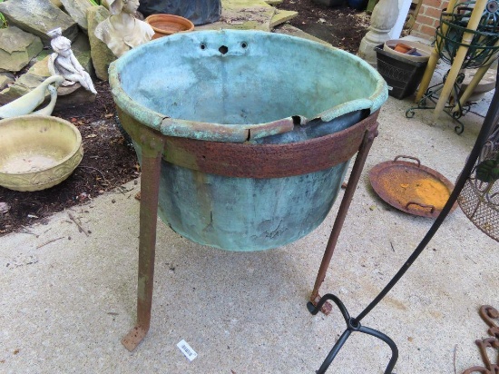 large copper cauldron with iron base