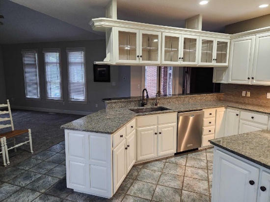 white kitchen cabinets with granite counters, sink with garbage disposal, coffee bar station, and