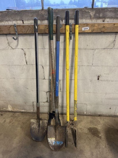 lot of two post hole diggers and shovels