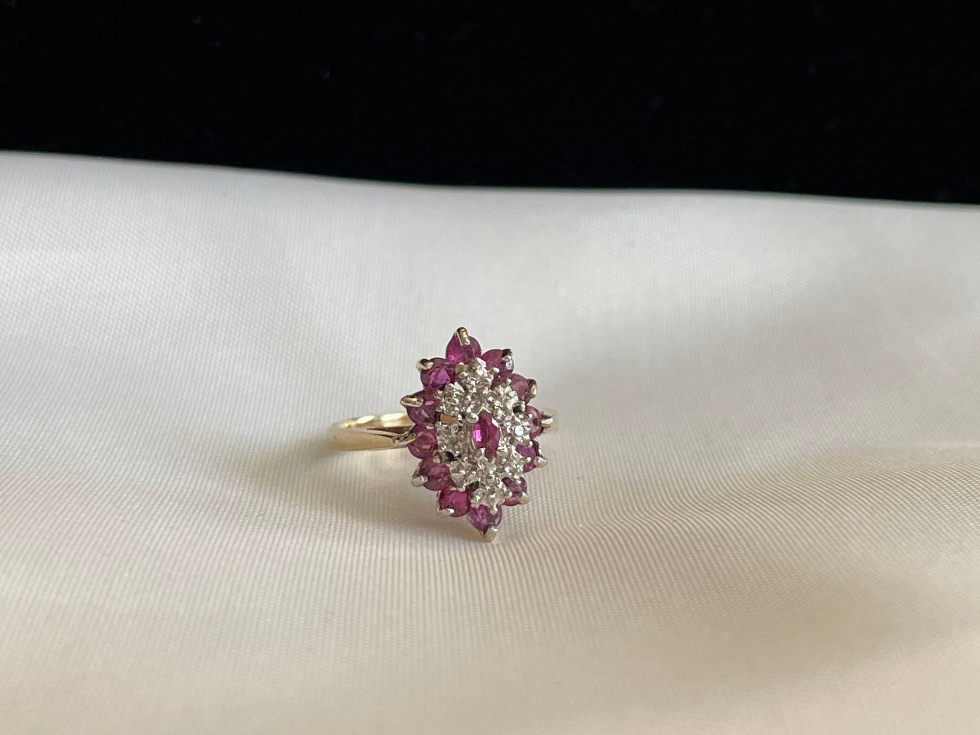 Gold colored ring with purple and clear stones. Proxibid