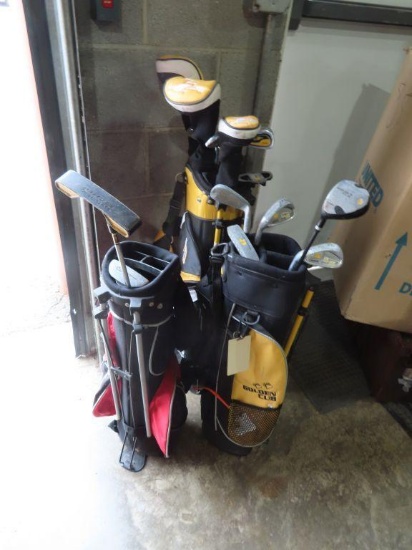 Lot of three youth golf bags with clubs
