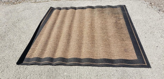 Black and brown outdoor rug measuring approximately 5.5 ft by 5.5 ft