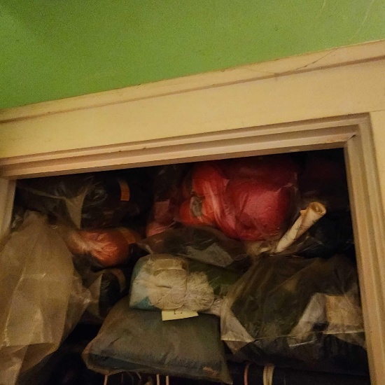 Lot of yarn and sewing supplies on shelf in closet