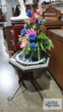 Wrought iron with stone top plant stand and floral arrangement